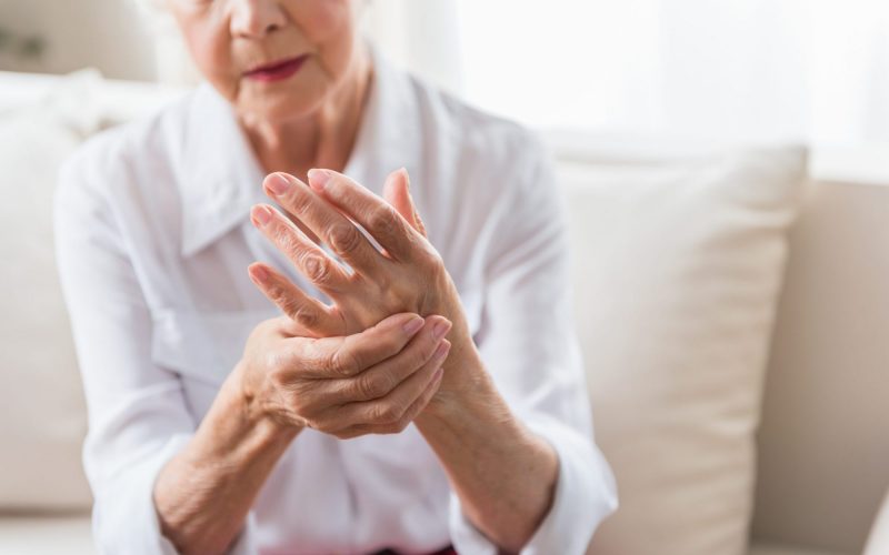 Arthritis. Close-up of hands of unhappy senior lady is feeling arm ache and expressing suffering. Copy space in the right side