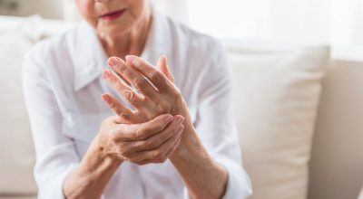 Elderly female is expressing pain Arthritis. Close-up of hands of unhappy senior lady is feeling arm ache and expressing suffering. Copy space in the right side