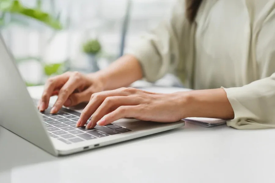 Hände tippen auf einer Laptop-Tastatur – Recherche zu Polyneuropathie